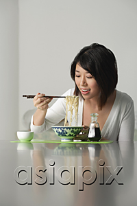 AsiaPix - Young woman eating a bowl of noodles