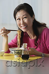 AsiaPix - Mature woman eating a bowl of noodles