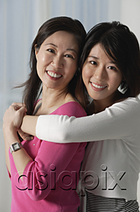 AsiaPix - Mother with grown daughter, embracing, looking at camera