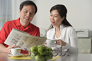 AsiaPix - Mature couple at home, looking at newspaper and having coffee