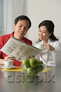 AsiaPix - Mature couple looking at newspaper and having coffee