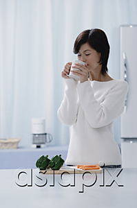 AsiaPix - Woman in kitchen, drinking from a cup