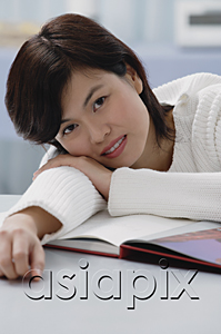 AsiaPix - Woman leaning on book, smiling at camera