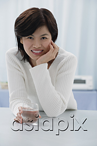 AsiaPix - Woman leaning in table, holding glass, hand on chin, portrait