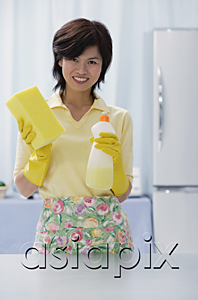 AsiaPix - Woman in kitchen, holding cleaning detergent and sponge