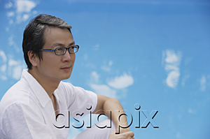 AsiaPix - Man with eyeglasses, looking away, water in the background