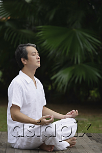 AsiaPix - Mature man sitting outdoors practicing Yoga