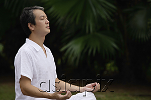 AsiaPix - Mature man sitting outdoors, meditating