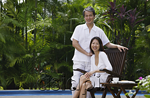AsiaPix - Couple relaxing outdoors by swimming pool, looking at camera, portrait