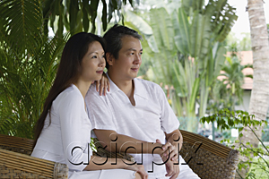 AsiaPix - Couple sitting on rattan chairs, looking away