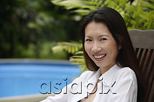 AsiaPix - Woman sitting outdoors, smiling at camera