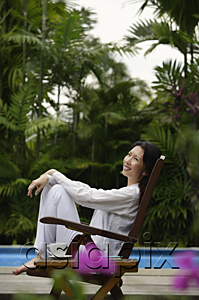 AsiaPix - Woman outdoors, sitting by swimming pool