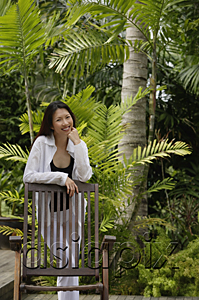 AsiaPix - Woman in garden, leaning on chair, smiling at camera