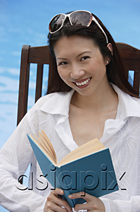 AsiaPix - Woman by swimming pool, reading a book