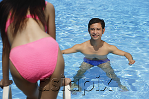 AsiaPix - Man in swimming pool, smiling at woman standing in front of him
