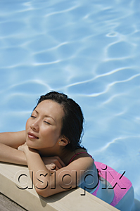 AsiaPix - Woman leaning at the edge of swimming pool, arms crossed, eyes closed, high angle view