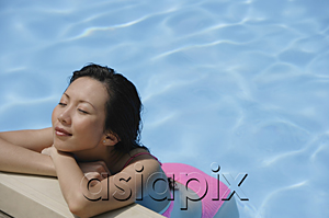 AsiaPix - Woman with eyes closed, leaning on the edge of swimming pool