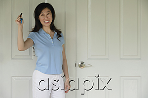 AsiaPix - Woman standing next to door, holding house keys, smiling