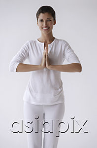 AsiaPix - Woman standing with hands in namaste, prayer, smiling, looking at camera