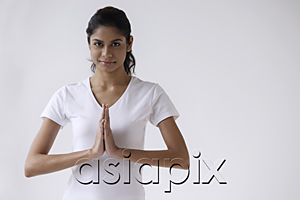 AsiaPix - Woman standing with hands in namaste, prayer, looking at camera
