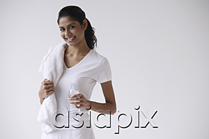 AsiaPix - Woman standing holding water bottle and towel over shoulder, smiling