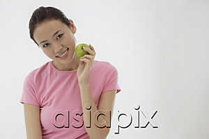 AsiaPix - woman holding apple, smiling at camera