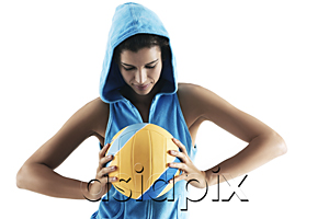 AsiaPix - Woman holding volley ball, looking at ball, wearing hood, sports