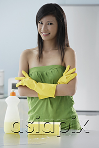 AsiaPix - woman in kitchen with cleaning products, arms crossed, smiling at camera