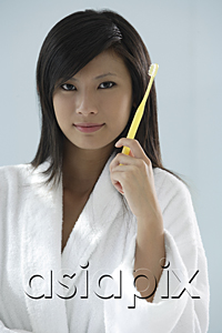 AsiaPix - woman holding toothbrush, looking at camera