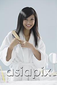 AsiaPix - woman wearing bathrobe, brushing hair and smiling at camera