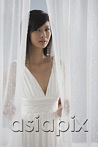AsiaPix - woman in white dress, looking through curtains at camera