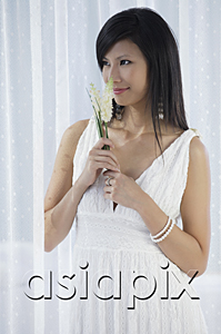 AsiaPix - woman in white dress holding flowers and smelling flowers
