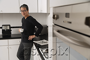 AsiaPix - Man in kitchen holding coffee cup, looking at camera