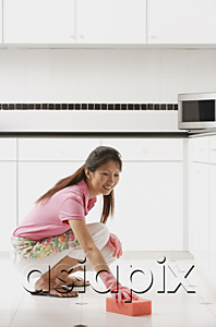 AsiaPix - woman wearing gloves cleaning kitchen floor