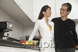 AsiaPix - Man and woman in kitchen getting ready for a meal, smiling at each other.
