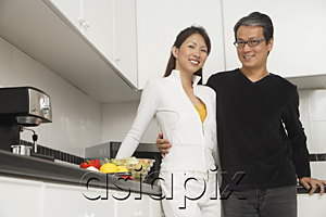 AsiaPix - Man and woman in kitchen preparing a meal, smiling at camera