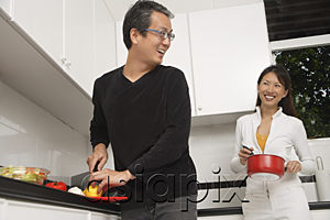 AsiaPix - Man and woman in kitchen preparing a meal, cooking, smiling at each other