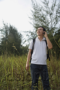 AsiaPix - Man talking on mobile phone, hiking, outdoors
