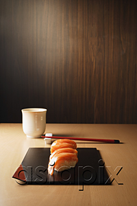 AsiaPix - four pieces of salmon sushi on tray, nigiri on rice ball, chopsticks and tea
