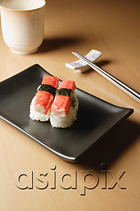 AsiaPix - 2 pieces of sushi, Kanikama Nigiri, crabstick on tray with chopsticks and tea