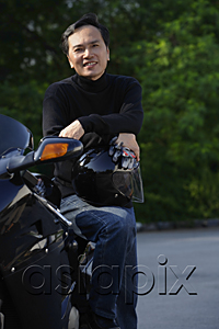 AsiaPix - Man leaning on motorcycle, holding helmet, smiling at camera