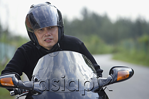 AsiaPix - Man wearing helmet and riding motorcycle