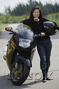 AsiaPix - Mature woman leaning against motorcycle, holding helmet