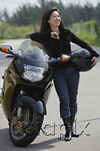 AsiaPix - Woman leaning against motorcycle, holding helmet, looking away from camera