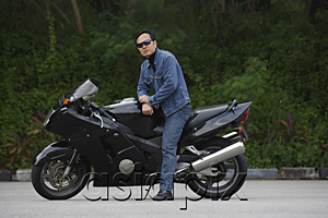 AsiaPix - Mature man sitting on motorcycle, wearing sunglasses