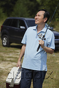 AsiaPix - Mature man holding fishing pole and cooler, smiling