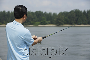 AsiaPix - Man fishing with fishing pole, rear view