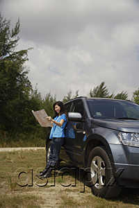 AsiaPix - Woman leaning against SUV, reading map