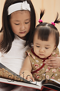 AsiaPix - Baby girl with older sister, reading book together
