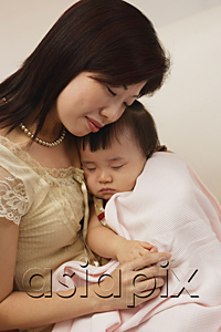 AsiaPix - Mother holding baby girl in arms, baby girl wrapped up in blanket, peaceful
